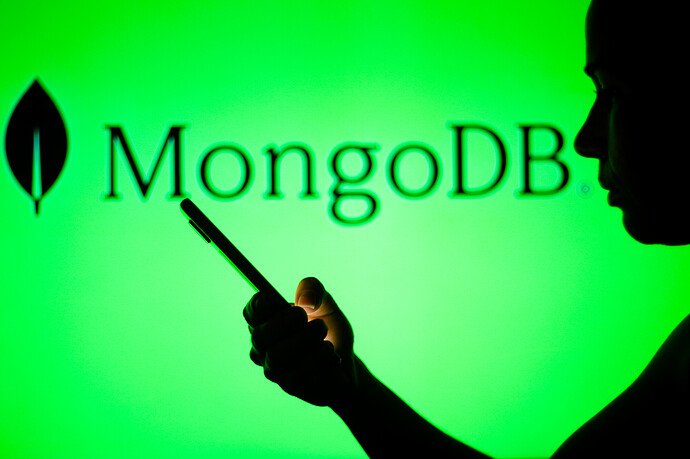 Das MongoDB-Logo ist im Hintergrund einer Silhouette einer Frau zu sehen, die ein Mobiltelefon hält