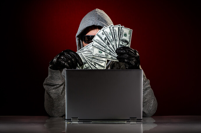 Hacker hält Geldscheine in die Luft