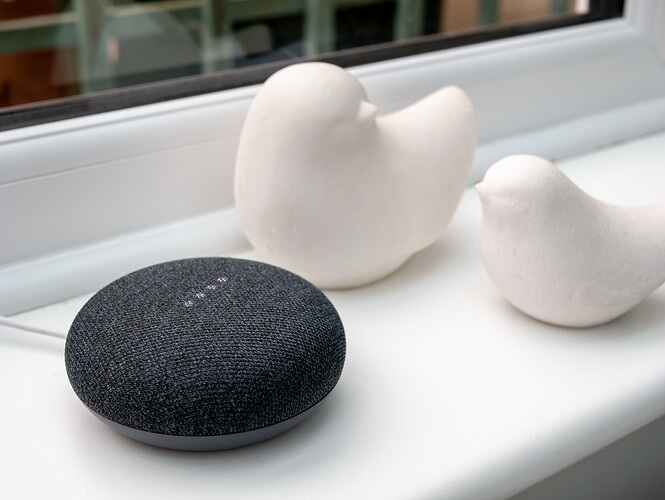 Ein Google Home Mini-Lautsprecher auf einer Fensterbank