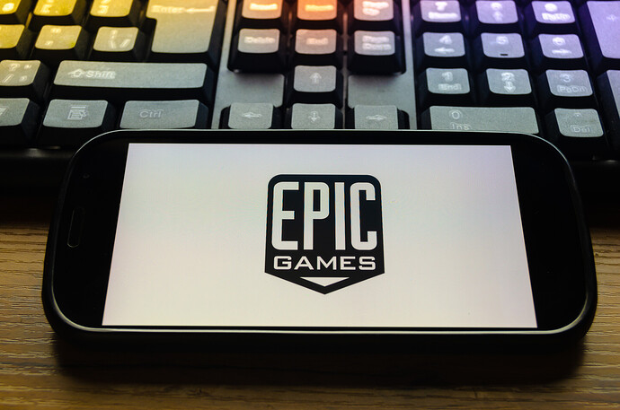 Mobiltelefon vor einer Tastatur mit dem Bildschirmlogo der Firma Epic Games