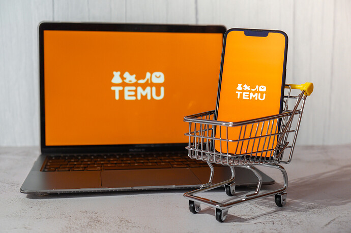 Temu-App-Symbol auf dem Bildschirm eines Apple MacBook und eines iPhone in einem Einkaufswagen