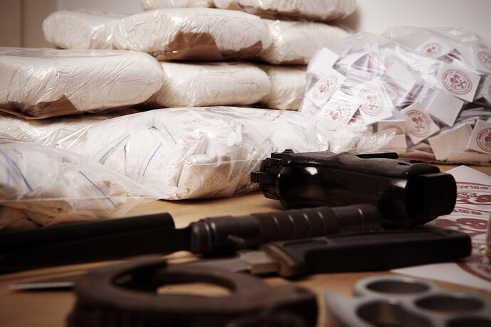 Päckchen mit Dutzenden von Drogen und Rohopium liegen neben Waffen auf einem Tisch