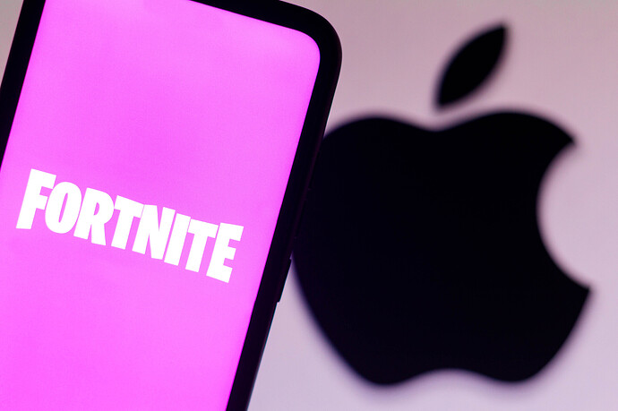 Das Fortnite-Logo auf einem Smartphone mit dem Apple-Logo im Hintergrund