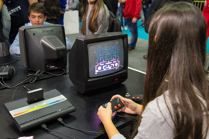Junge Frau spielt auf einer alten Atari-Spielekonsole