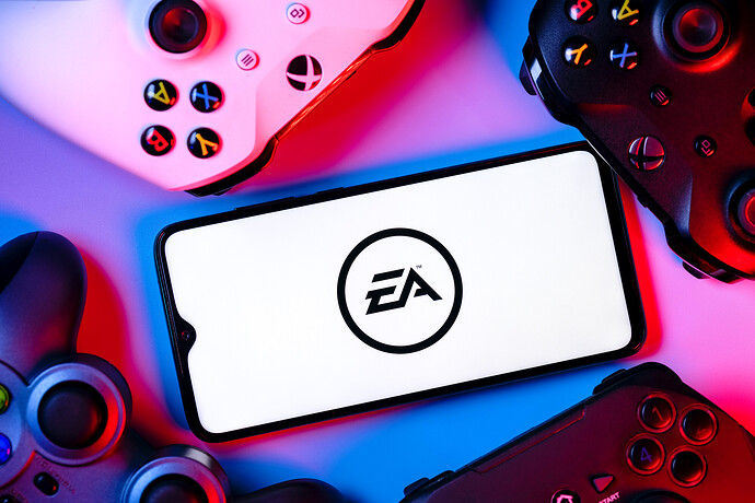 Ein Smartphone mit dem Logo von Electronic Arts auf dem Bildschirm, umgeben von Gamepads