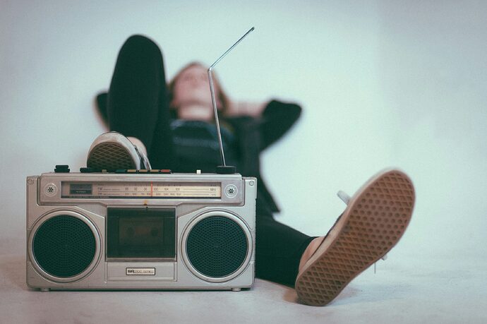 Eine Frau liegt auf einem Bett in der Nähe von einem grauen Radio.
