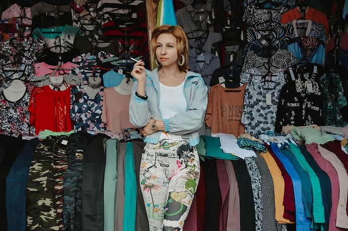 Hehlerei Flohmarkt, Verkäuferin raucht vor ihren Jeans eine Zigarette