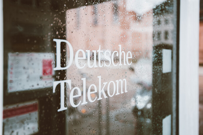 Schriftzug "Deutsche Telekom" auf einer verregneten Fensterscheibe