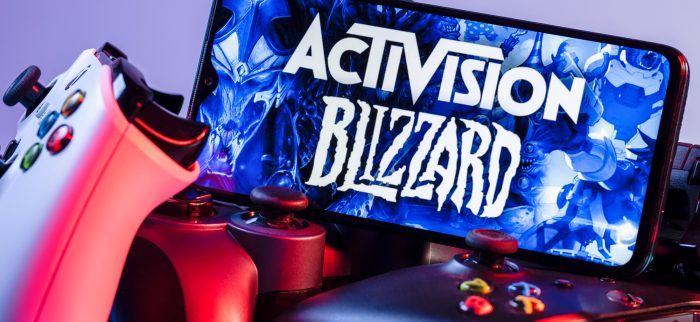 Auf Controllern aufgestelltes Smartphone mit dem Logo von Activision Blizzard