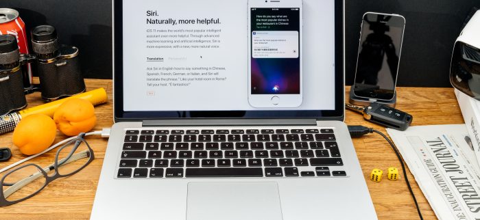 Zwei Apple-Systeme in einem Bild vereint: MacBook mit macOS und iPhone mit iOS