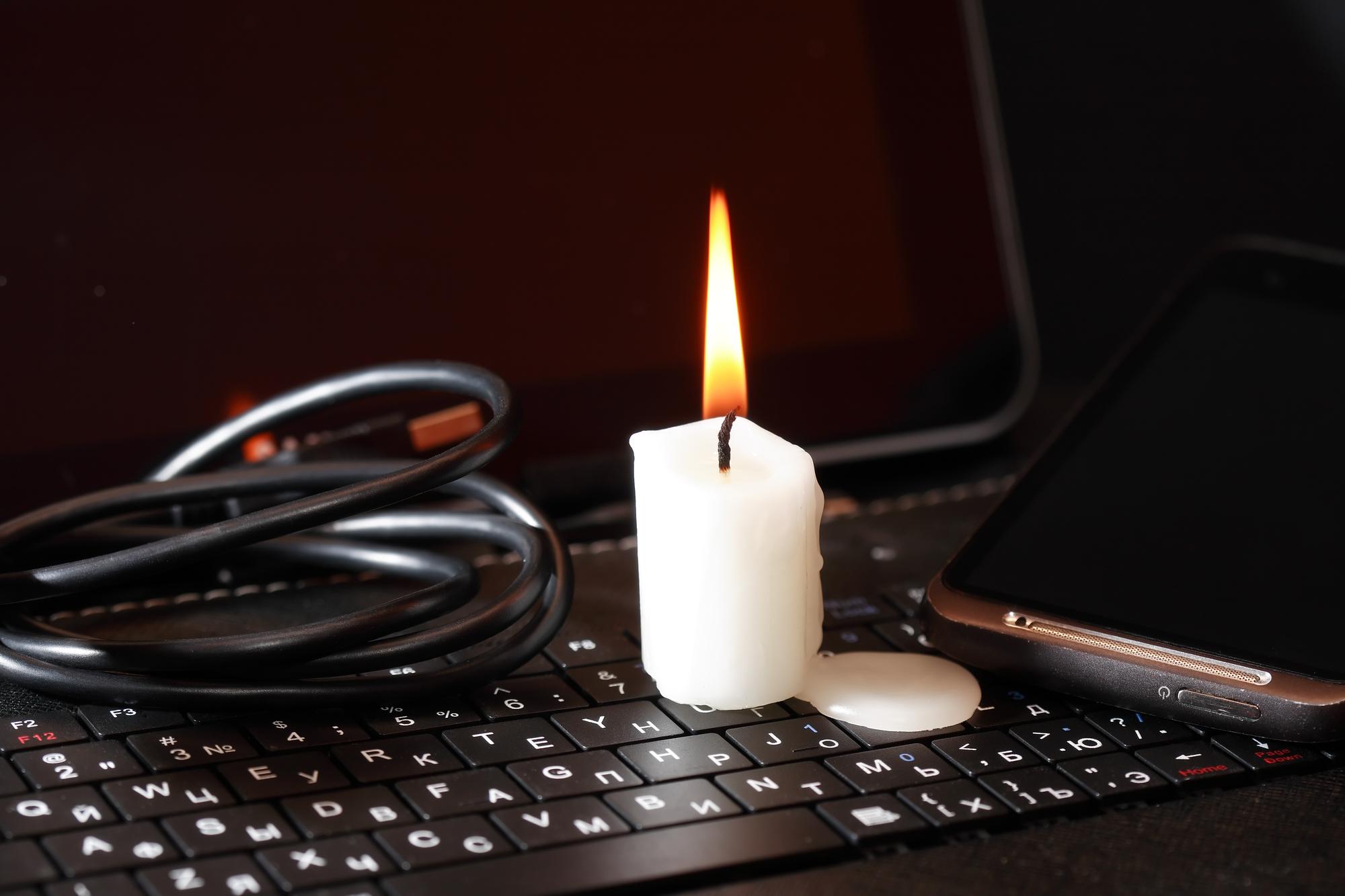 Eine Kerze brennt auf einem Laptop