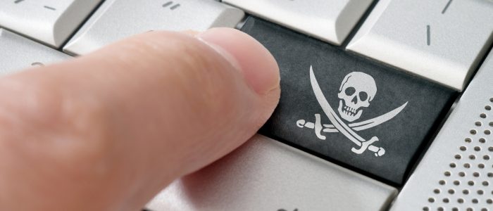 Raubkopierer drückt eine Piratensymbol-Eingabetaste auf einer Laptoptastatur