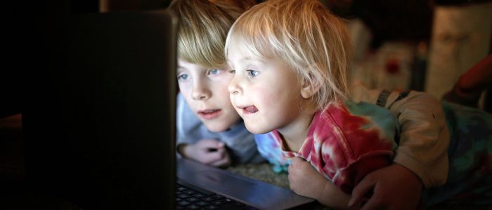 Sicherheit im Netz: Zwei kleine Kinder sehen sich auf ihrem Laptop Internetvideos an.