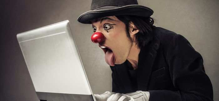 Ein staunender Clown sitzt vor einem Laptop und liest die Glosse