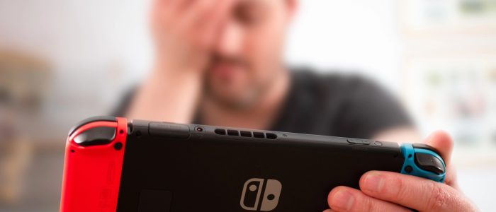 Nintendo Switch-Spieler mit Hand an Kopf