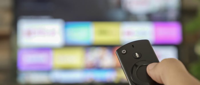 Eine Hand hält eine FireTV-Stick-Fernbedienung