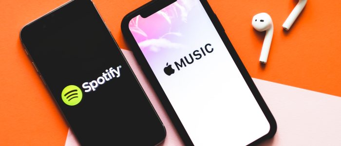 Zwei Smartphones mit den Logos von Apple Music und Spotify