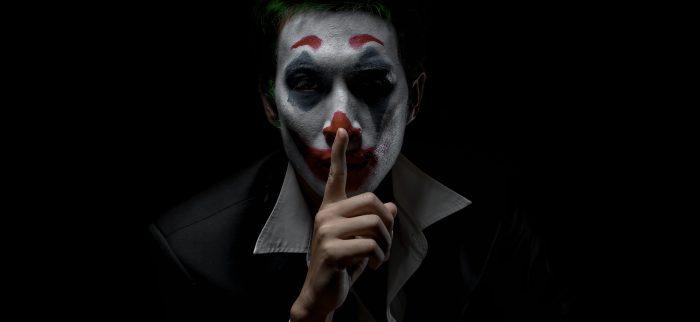 Ein Mann mit Joker-Makeup vor einem dunklen Hintergrund