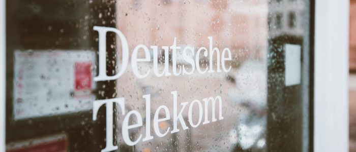 Schriftzug "Deutsche Telekom" auf einer verregneten Fensterscheibe