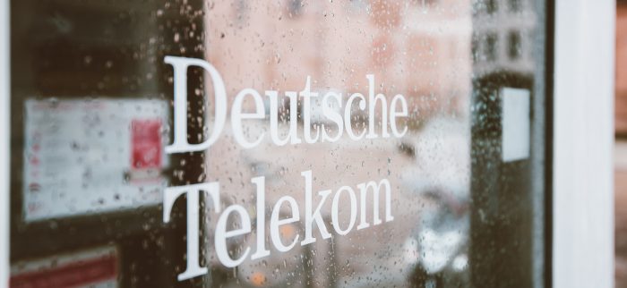 Schriftzug "Deutsche Telekom" auf einer verregneten Fensterscheibe