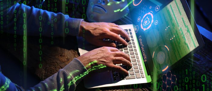 Hacker mit Computer in einem dunklen Raum