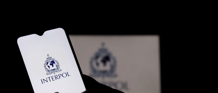 Ein Smartphone mit dem Interpol-Logo auf dem Display