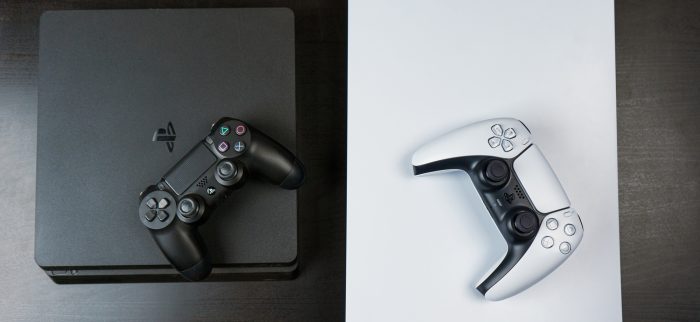 Eine schwarze PS4 und eine weiße PS5 liegen nebeneinander