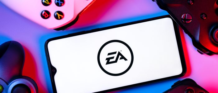 Ein Smartphone mit dem Logo von Electronic Arts auf dem Bildschirm, umgeben von Gamepads