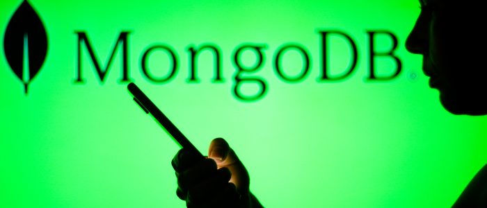 Das MongoDB-Logo ist im Hintergrund einer Silhouette einer Frau zu sehen, die ein Mobiltelefon hält