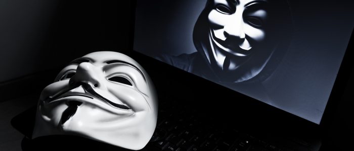 Eine Vendetta-Maske auf einem Laptop mit einem Anonymous-Mitglied auf dem Bildschirm