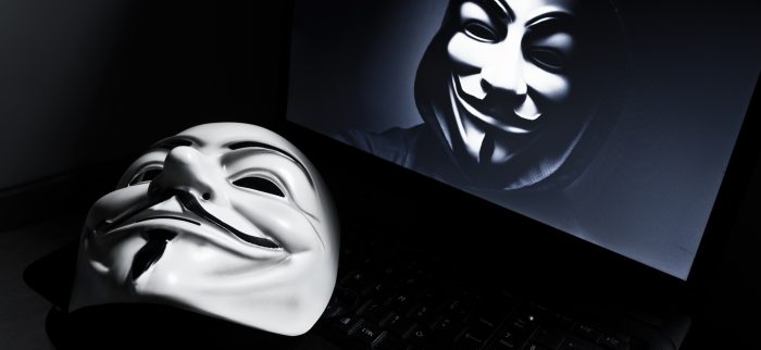 Eine Vendetta-Maske auf einem Laptop mit einem Anonymous-Mitglied auf dem Bildschirm