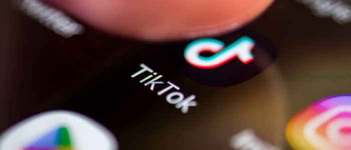 Jemand drückt auf das Symbol der Social-Media-Anwendung TikTok auf dem Bildschirm eines Smartphones