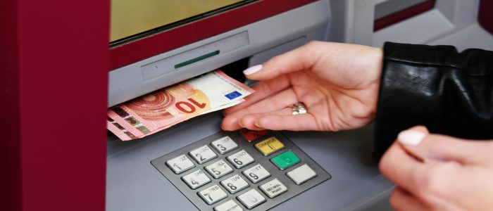 Eine Frau hebt Geld von einem Bankautomaten ab