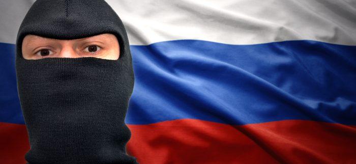 Mann mit Maske auf einem Hintergrund mit russischer Flagge