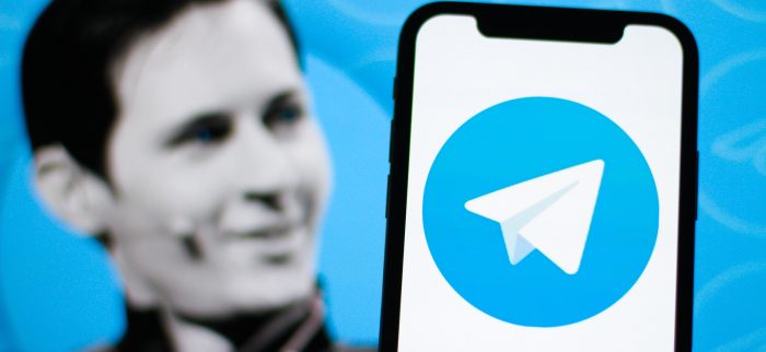 Das Logo von Telegram auf einem Smartphone. Im Hintergrund der Gründer von Telegram. Pavel Durov