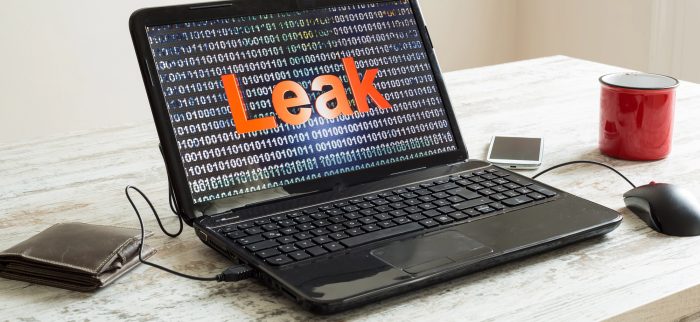 Ein Laptop steht auf einem Tisch und zeigt das Wort "Leak" vor Binärcode