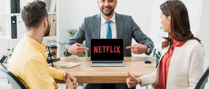 Geschäftsmann zeigt auf Notebook mit Netflix-Logo