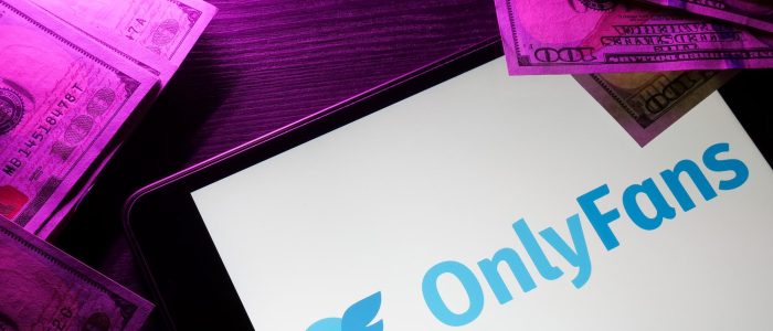 Tablet mit OnlyFans-Logo und Geld