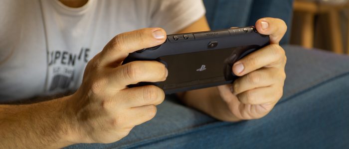 Mann spielt auf einer PS Vita