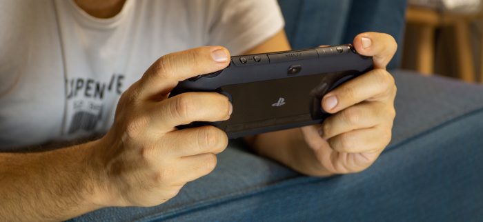 Mann spielt auf einer PS Vita