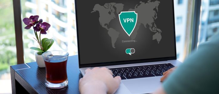 Eine Person sitzt vor einem Notebook mit aktiver VPN-Verbindung