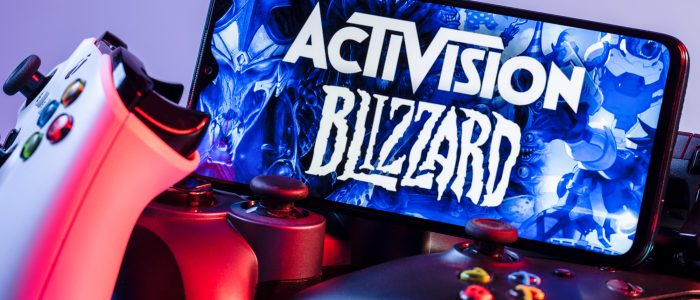 Auf Controllern aufgestelltes Smartphone mit dem Logo von Activision Blizzard