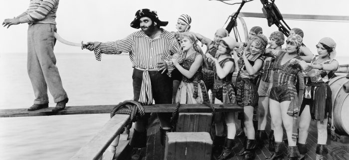 Eine Gruppe von Piraten schickt einen jungen Mann über die Planke