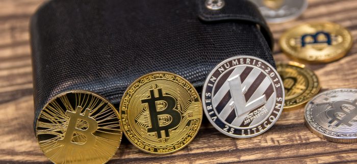 Bitcoins, Litecoins und Ethereum im schwarzen Lederportemonnaie.