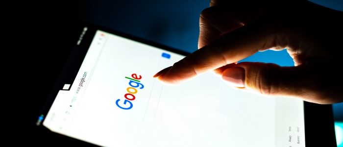 Nahaufnahme einer Frauenhand mit Tablet und google