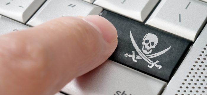 Raubkopierer drückt eine Piratensymbol-Eingabetaste auf einer Laptoptastatur