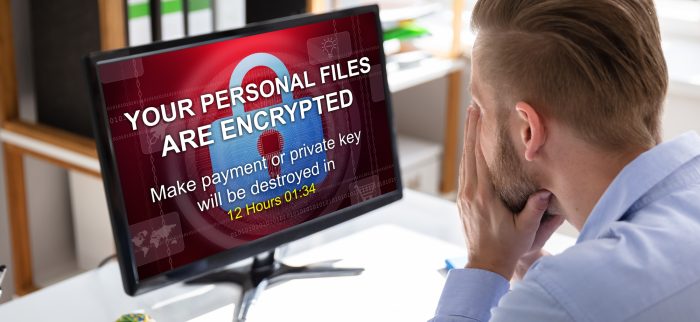Besorgter Geschäftsmann schaut nach einem Ransomware-Angriff auf seinen Computer