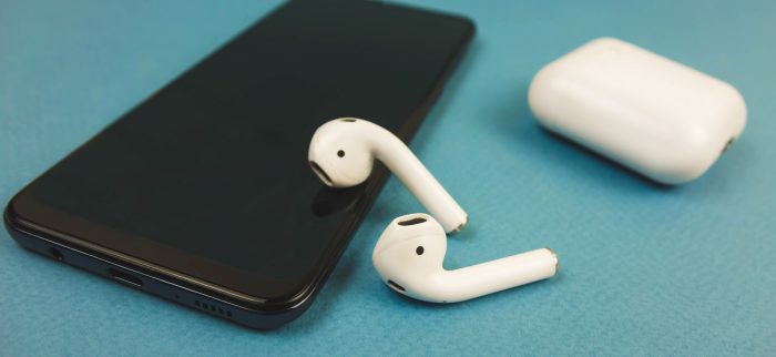 Apple-Kopfhörer auf einem schwarzen Telefon