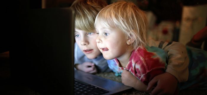 Sicherheit im Netz: Zwei kleine Kinder sehen sich auf ihrem Laptop Internetvideos an.