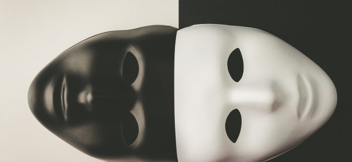 Schwarze und weiße Masken auf kontrastierendem Hintergrund
